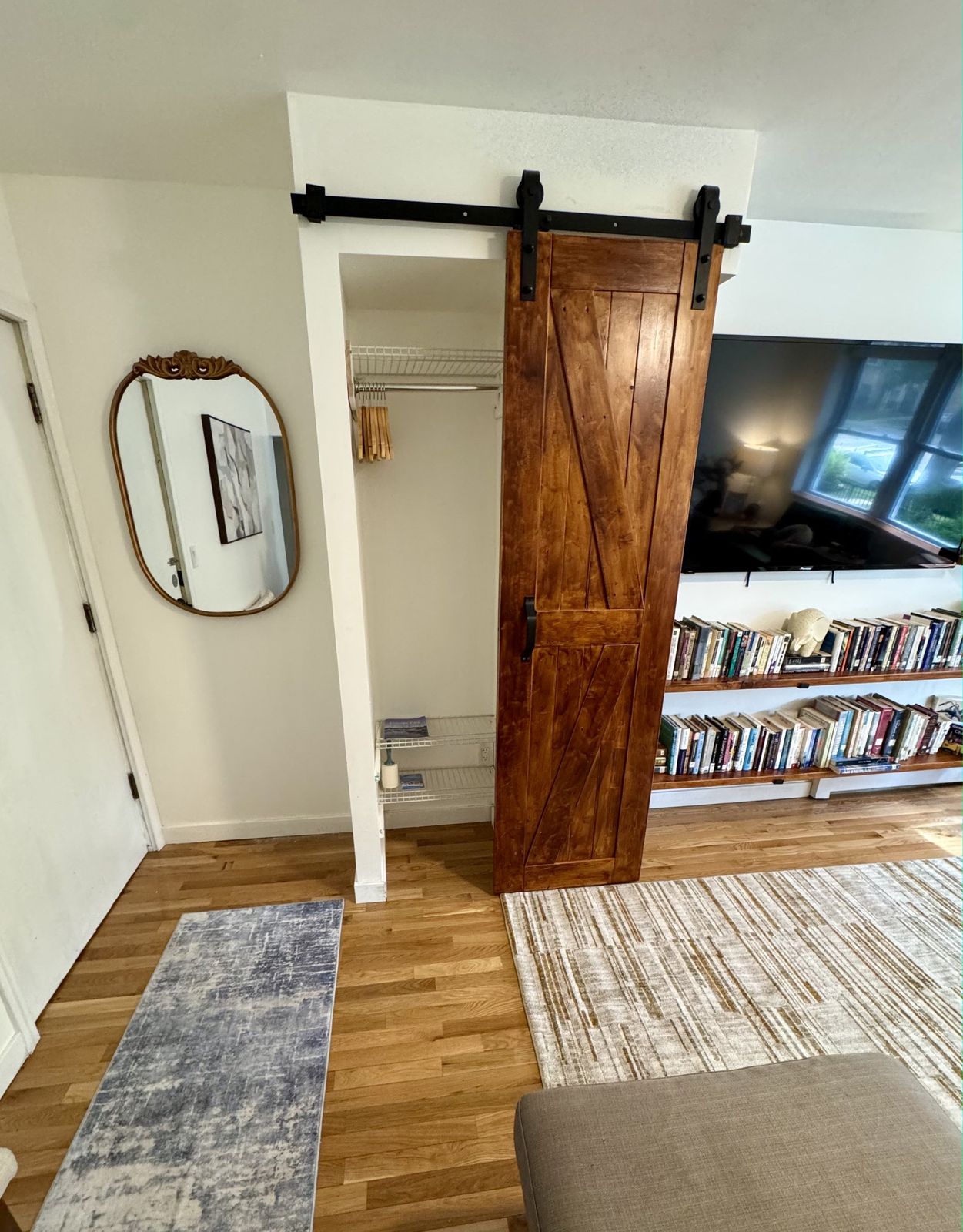 A sliding wooden barn door beside an oval mirror