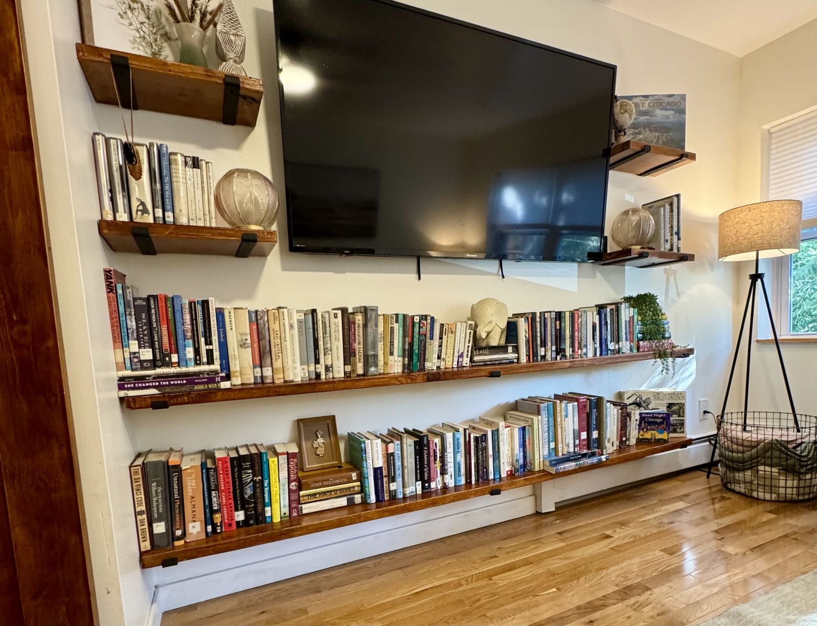 Long wooden shelves of books around a wall mounted television